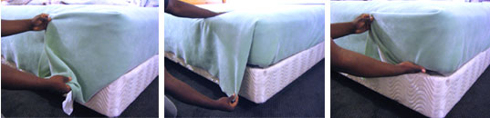 Tuck the top sheet and blanket together under the foot of the mattress. When you are done, the dangling fabric at the sides of the foot will have made a short U-turn back along the length of the bed. Pinch the U between your fingers and pull it toward the headboard, parallel to the mattress. Then, tuck the hanging corners of the sheet and blanket together under the mattress.
